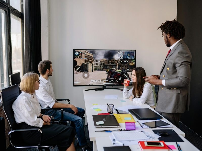 Diverse group of colleagues engaging in video game session during office hours.