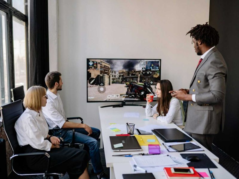 Diverse group of colleagues engaging in video game session during office hours.